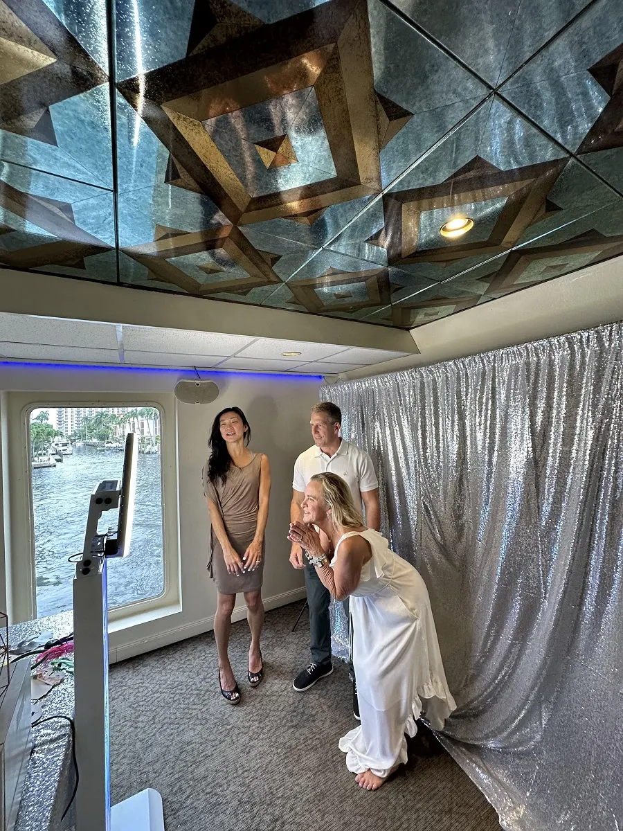 Guests posing in front of a silver sequin photo booth backdrop