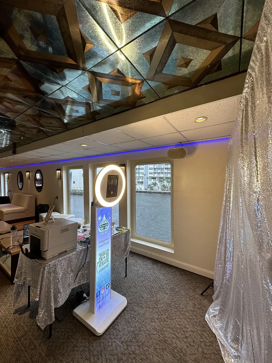 Ring-light photo booth with a silver sequin backdrop set up in a mirrored event room